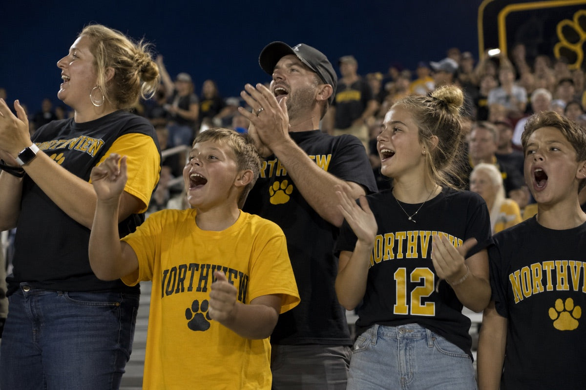 Fans cheering in the stands wearing custom spirit wear